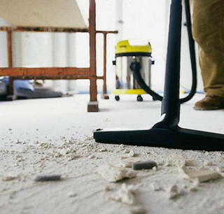 Shop vacuum cleaning construction debris on floor