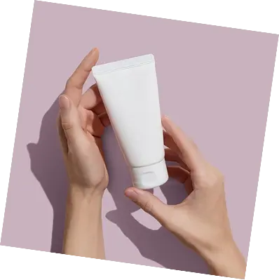 Two hands holding white skincare tube
